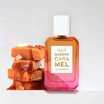 Queens Caramel 50ml bottle next to pieces of caramel with caramel drips and salt on a grey background. 