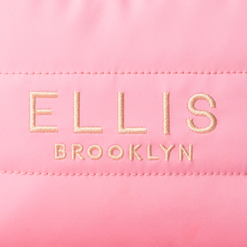 Close up of Pink Cosmetic Bag with gold embroidery that reads "Ellis Brooklyn" 
