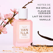 Eau de parfum VANILLA RICE (50 ml), présentée aux côtés de riz grillé, de gousses de vanille et de fleurs de cerisier (sakura) roses sur un fond rose, avec un texte gris indiquant : « Notes de riz grillé, fleur de cerisier, lait de coco, vanille ».