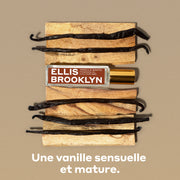 Huile parfumée Vanille Santo 15 ml avec des morceaux de bois et des gousses de vanille sur un arrière-plan brun, au-dessus d’un texte blanc qui dit « Une vanille sensuelle et mature ».