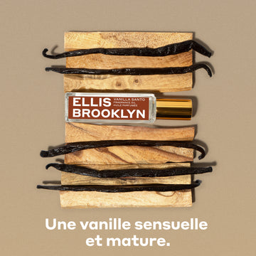 Huile parfumée Vanille Santo 15 ml avec des morceaux de bois et des gousses de vanille sur un arrière-plan brun, au-dessus d’un texte blanc qui dit « Une vanille sensuelle et mature ».