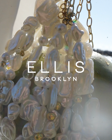 Close up of white shell and gold bead bag with gold chain in front of a green coconut and blue sky with white text that reads "Ellis Brooklyn"