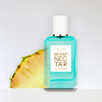 Blue Miami Nectar 50ml bottle with sliced pineapple on grey background. 