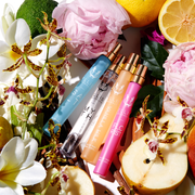 Spray voyage Eau de Parfum Salt 10ml, Spray voyage Eau de Parfum Myth 10ml, Spray voyage Eau de Parfum Vanilla Milk 10ml et Spray voyage Eau de Parfum Florist 10ml sur fond blanc, entourés de bergamote, de citrons, de fleurs roses, de fleurs blanches, de fleurs jaunes, de poires, de feuilles vertes, de bois de santal et de gousses de vanille.