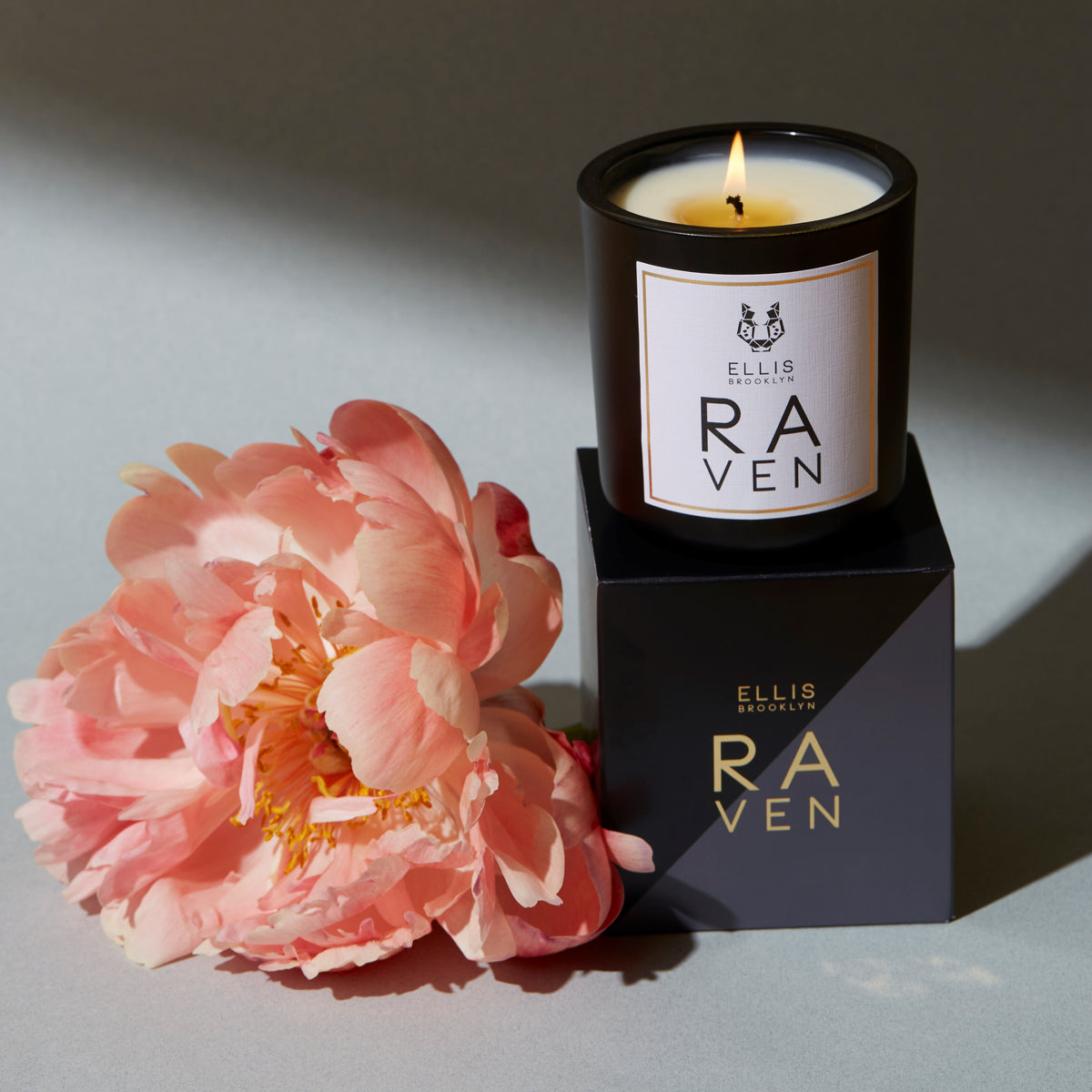 RAVEN candle near flowers on box 