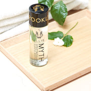 IMAGE 4: MYTH body oil ON TABLE WITH FLOWER