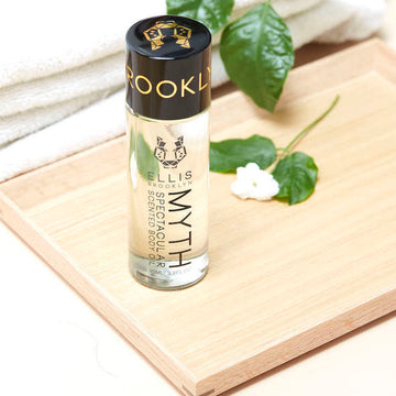 IMAGE 4: MYTH body oil ON TABLE WITH FLOWER