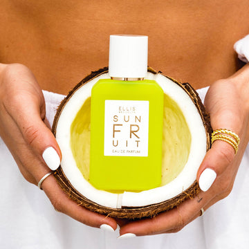 IMAGE 6: MODEL HOLDING SUN FRUIT 50ML BOTTLE IN COCONUT